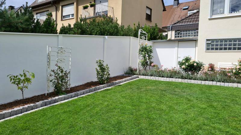 Gartenhaus mit begrüntem Dach zwischen Hauswand und Sichtschutz von Modulare Wandsysteme